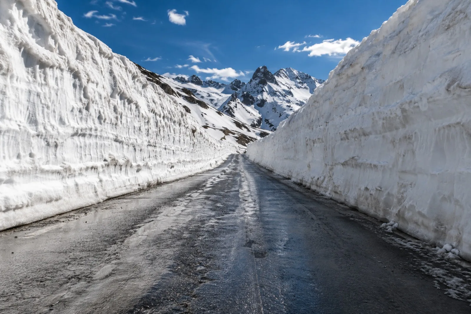 Schneeräumfahrzeug auf einer verschneiten Passstraße im Frühjahr